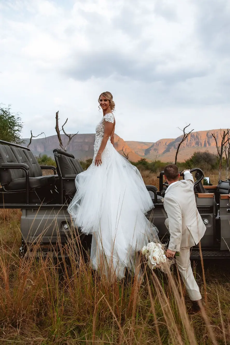 Braut in weißem Kleid, Safari-Fahrzeug