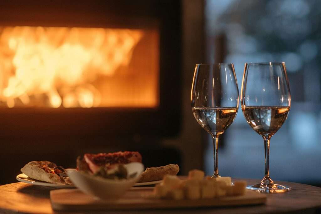 Wein und Snacks vor dem Kamin